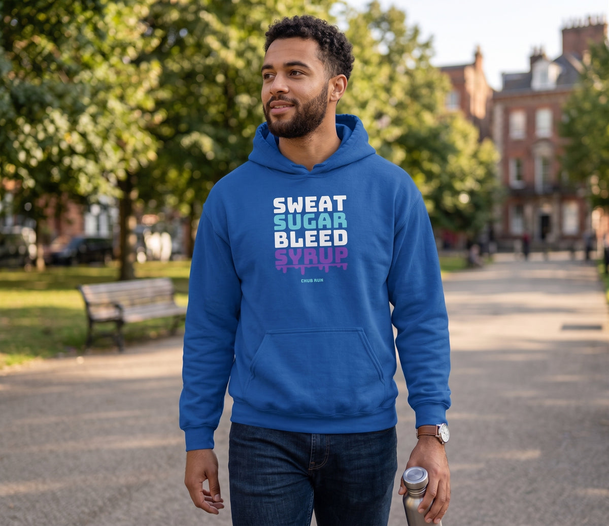 Runner walking through a park in the royal blue Chub Run Sweat Sugar Bleed Syrup pullover hoodie